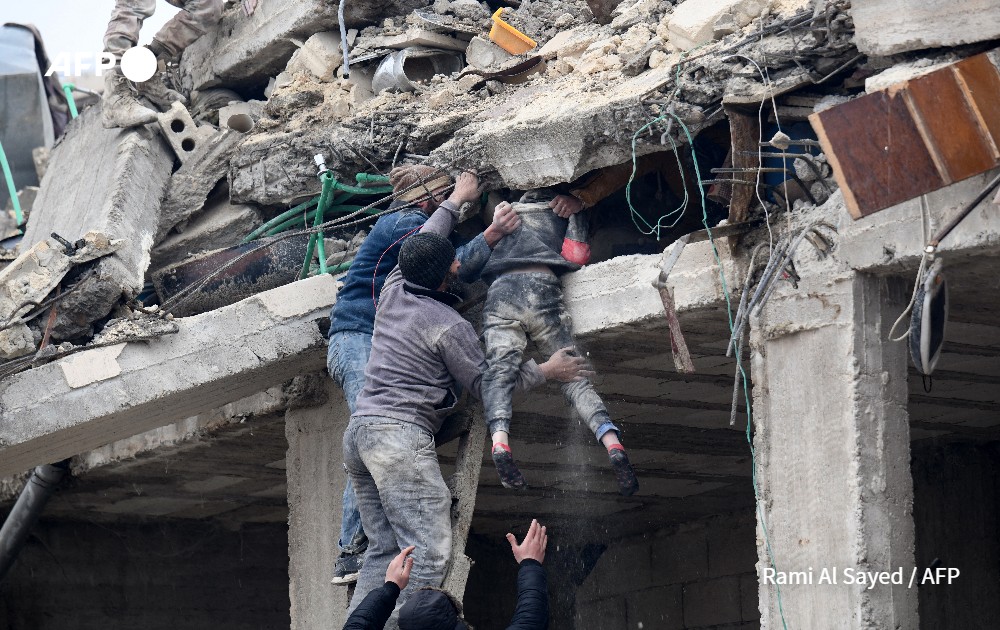 Residents retrieve an injured girl from the rubble of a collapsed building following an earthquake in the town.